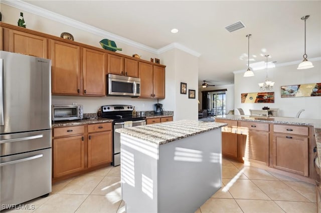 kitchen with light tile patterned floors, brown cabinetry, visible vents, a kitchen island, and stainless steel appliances