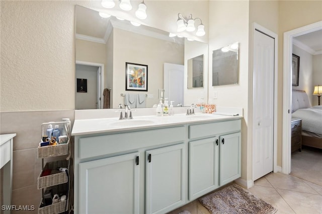 bathroom with a sink, ornamental molding, ensuite bathroom, and tile patterned floors