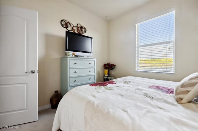 bedroom featuring light colored carpet and baseboards