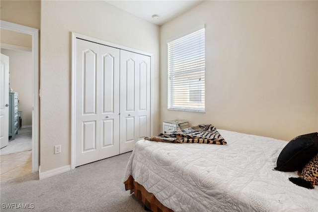 bedroom with carpet, a closet, and baseboards