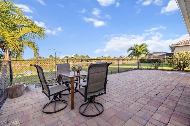 view of patio featuring outdoor dining area and fence