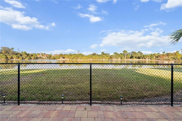 view of yard with a water view and fence