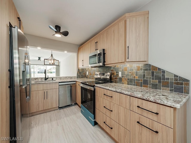 kitchen featuring sink, backsplash, stainless steel appliances, light stone countertops, and light brown cabinets