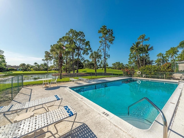 view of swimming pool with a patio area and a water view