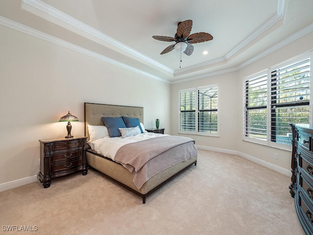 carpeted bedroom with a raised ceiling, crown molding, and ceiling fan