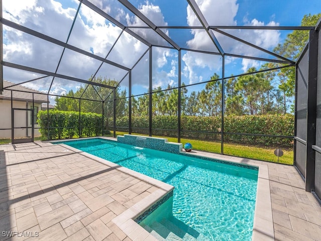 view of pool featuring pool water feature, glass enclosure, and a patio area