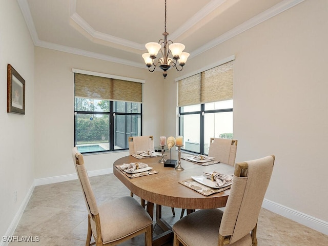 dining space with a chandelier, crown molding, and a raised ceiling