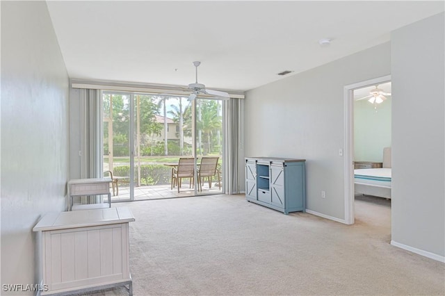 interior space featuring visible vents, baseboards, carpet, and ceiling fan