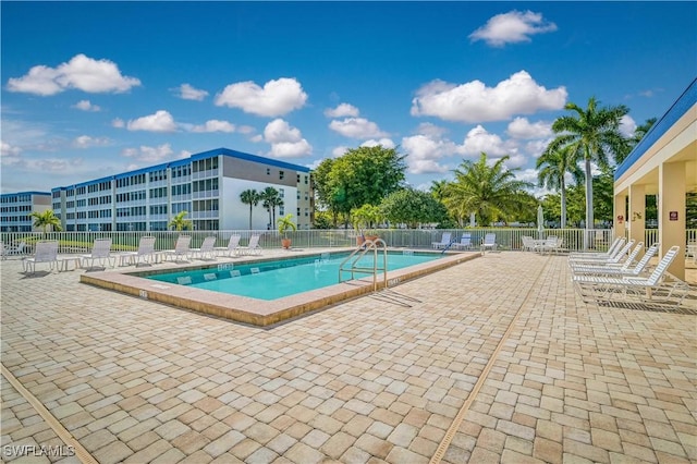 pool with a patio and fence