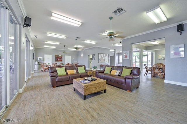 living area with visible vents, wood finished floors, and crown molding