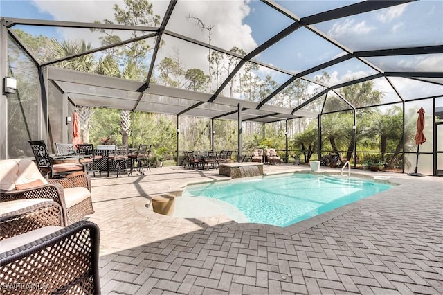 view of pool with pool water feature, a patio area, and glass enclosure