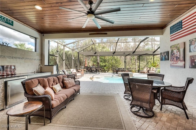 view of patio / terrace featuring an outdoor living space, ceiling fan, and glass enclosure