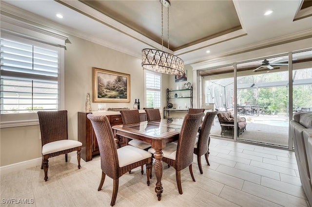 dining space featuring ornamental molding, a healthy amount of sunlight, ceiling fan, and a tray ceiling