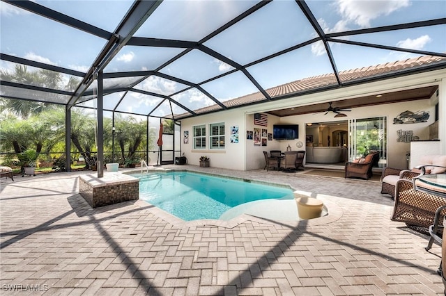 view of swimming pool featuring an outdoor hangout area, a patio, ceiling fan, and glass enclosure