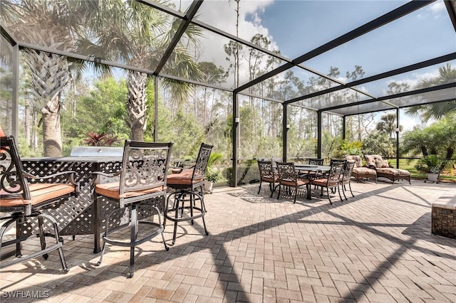 view of patio / terrace featuring glass enclosure and exterior bar