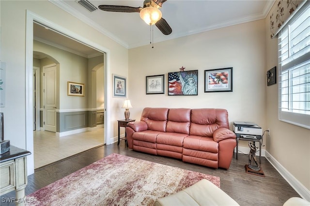 living room featuring dark wood-type flooring, ceiling fan, and ornamental molding