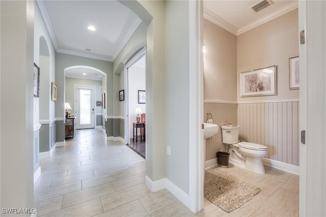 bathroom featuring crown molding and toilet