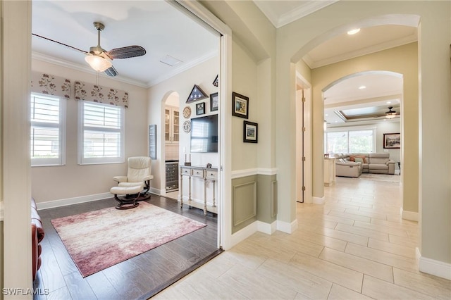 sitting room with ceiling fan, ornamental molding, and light hardwood / wood-style floors