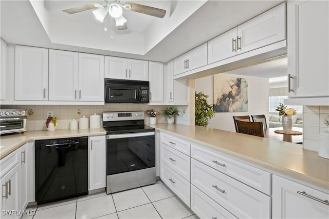 kitchen featuring black appliances, a raised ceiling, kitchen peninsula, white cabinets, and backsplash