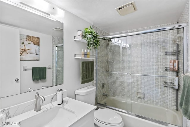 full bathroom featuring vanity, enclosed tub / shower combo, and toilet