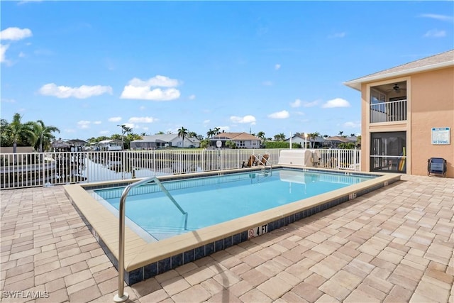 view of swimming pool featuring a water view and a patio area