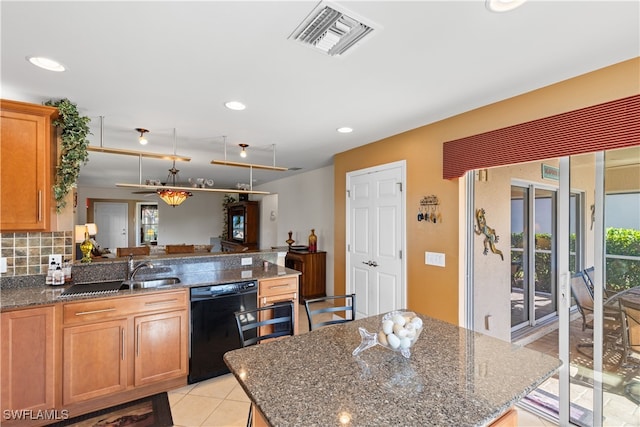 kitchen featuring sink, tasteful backsplash, a center island, dark stone countertops, and black dishwasher