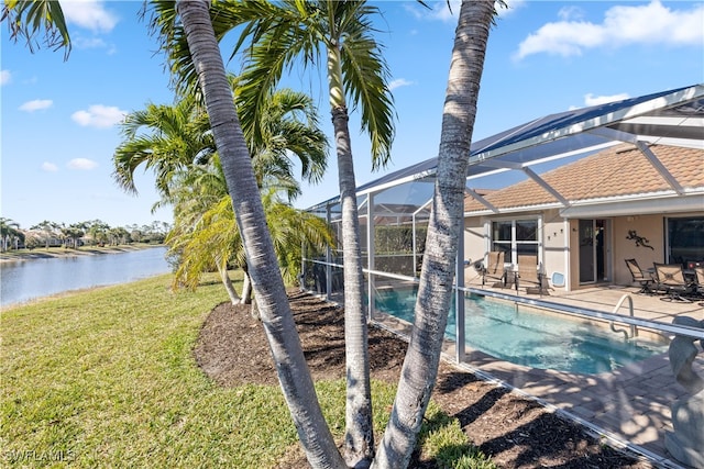 view of pool featuring a water view, a lanai, a yard, and a patio area