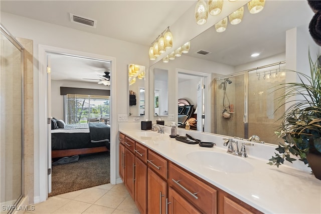 bathroom with tile patterned flooring, vanity, a shower with shower door, and ceiling fan