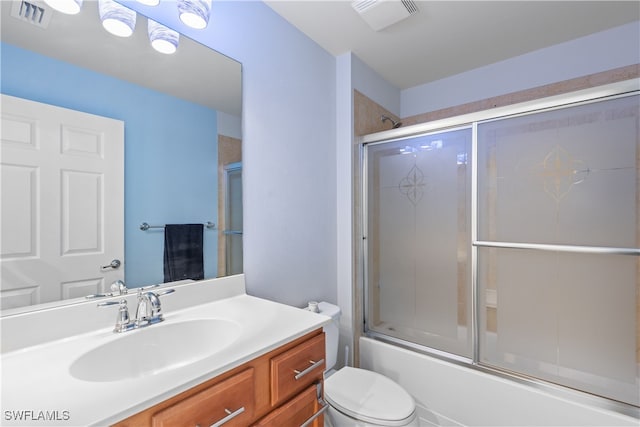 full bathroom featuring vanity, enclosed tub / shower combo, and toilet