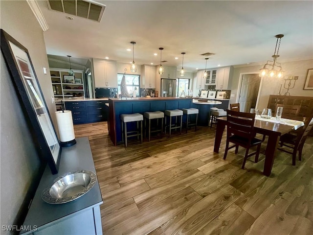 dining room with crown molding and light hardwood / wood-style flooring