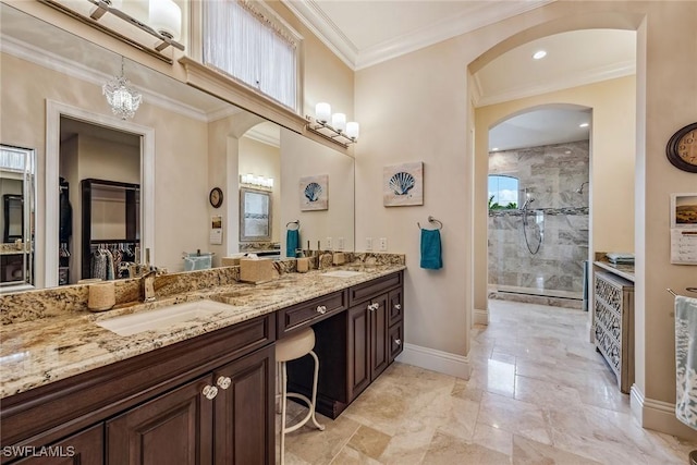 bathroom with tiled shower, ornamental molding, and vanity