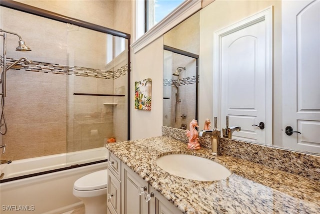 full bathroom with vanity, toilet, and combined bath / shower with glass door