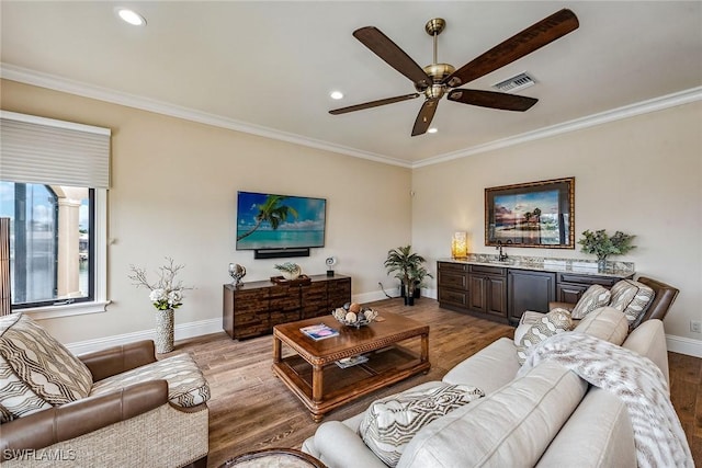 living room featuring crown molding, ceiling fan, sink, and light hardwood / wood-style flooring