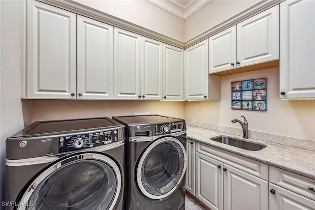 laundry area featuring independent washer and dryer, cabinets, and sink