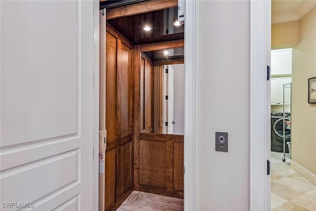 interior space featuring crown molding, elevator, and washer and clothes dryer