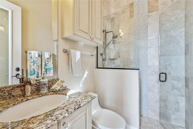 bathroom featuring vanity, toilet, and a shower with shower door