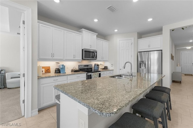 kitchen featuring white cabinetry, an island with sink, appliances with stainless steel finishes, and sink