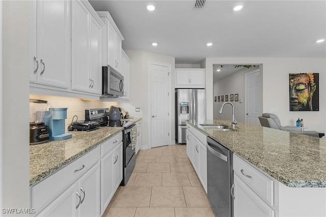 kitchen featuring sink, stainless steel appliances, an island with sink, and white cabinets