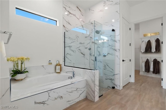 bathroom with independent shower and bath and hardwood / wood-style flooring