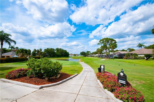 view of property's community with a yard and view of golf course