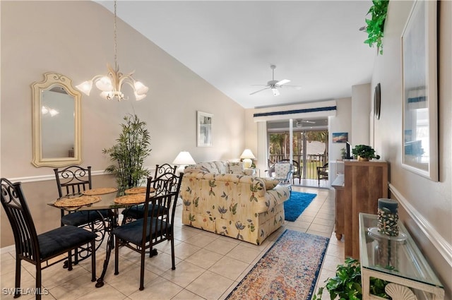 dining space featuring lofted ceiling, ceiling fan with notable chandelier, and light tile patterned flooring