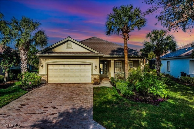 ranch-style home with a yard and a garage