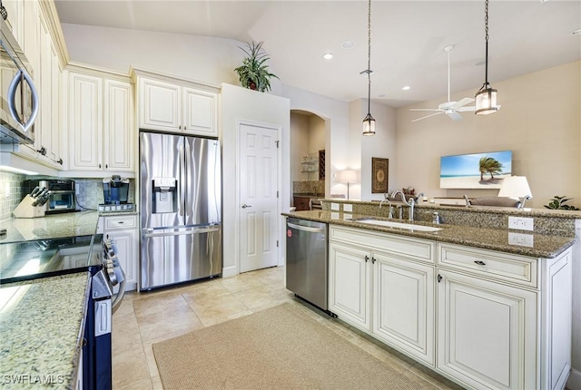 kitchen featuring sink, decorative light fixtures, appliances with stainless steel finishes, dark stone counters, and decorative backsplash