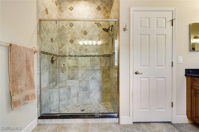 bathroom with vanity, an enclosed shower, and tile patterned flooring