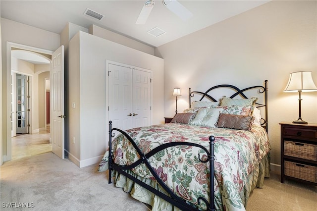 bedroom featuring light colored carpet, a closet, and ceiling fan