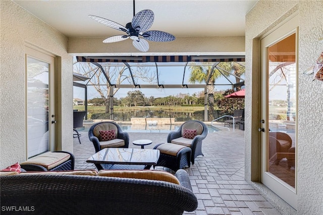 sunroom / solarium featuring ceiling fan