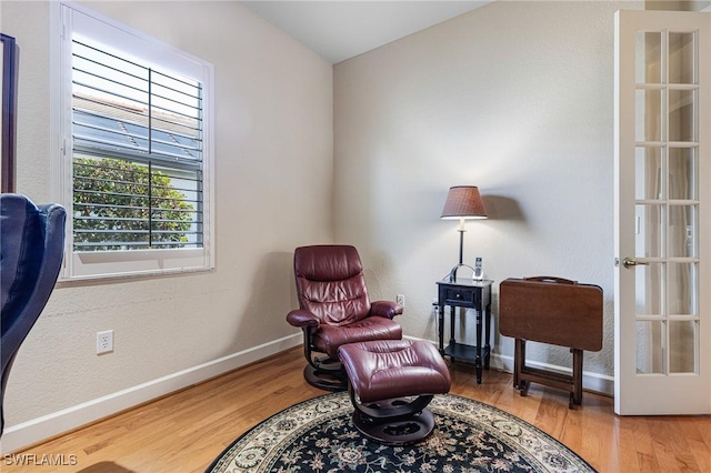 sitting room featuring wood-type flooring and french doors