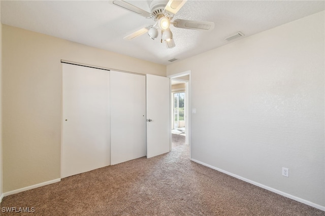 unfurnished bedroom with carpet floors, ceiling fan, and a closet