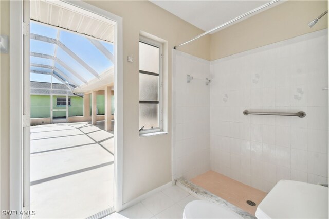 bathroom featuring a tile shower and toilet