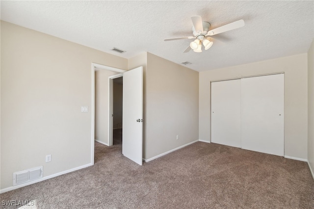 unfurnished bedroom with ceiling fan, a closet, carpet, and a textured ceiling